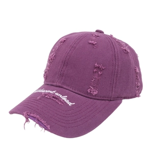 Detail of purple vintage baseball cap with distressed brim and Adolescent embroidery