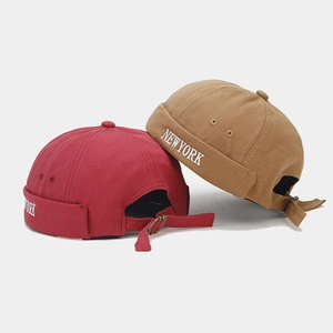 Detail of New York embroidery on red and brown canvas brimless docker hats with metal buckle