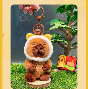 Close-up of cute plush capybara keychain with a brown metal clasp and small bell