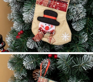 Detailed view of burlap Christmas stocking with 3D snowman and plaid trim hanging on a tree