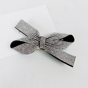 Detailed view of luxury black rhinestone bow hair clip with sparkling crystal accents