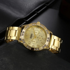 Close-up of golden quartz watch with crystal bezel on dark textured stone