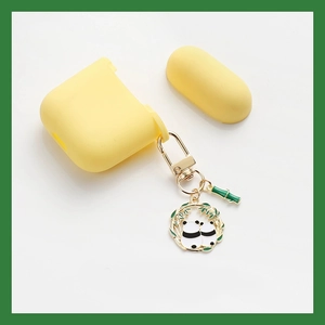 Detail of yellow silicone case with metallic panda and bamboo charms for earphones