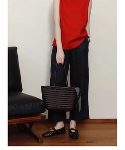 Detail of hand-woven leather tote bag with polka dot scarf and minimalist interior