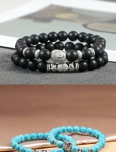 Macro detail of elastic beaded bracelet with owl and buddha silver charms in two colors