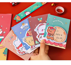 Close-up of cute cartoon Christmas memo pads and cards with festive bear designs