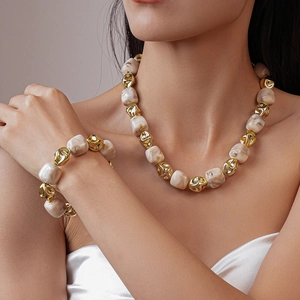 Detail of necklace and bracelet set with irregular marble beads and golden metal accents