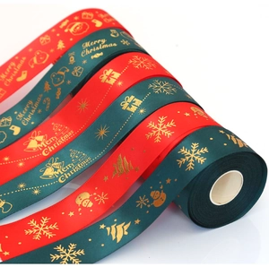 Macro detail of red and green Christmas ribbons with gold foil snowflakes and deer patterns