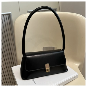 Detailed macro view of minimalist black leather shoulder bag with golden metallic lock