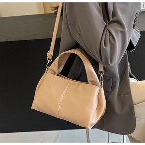 Detail of minimalist beige PU leather handbag with adjustable strap and wide handle