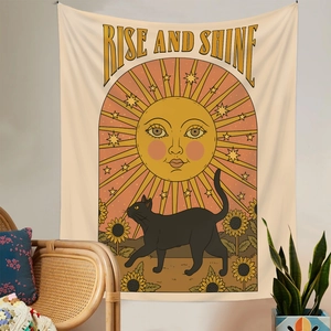 Detail of bohemian tapestry featuring a sun, black cat, and sunshines with text