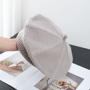 Detailed texture of light gray knit beret made of soft wool blend yarn in a lifestyle setting