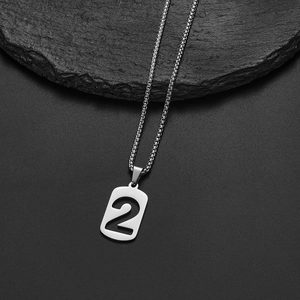 Detailed macro view of silver stainless steel necklace with number two hollow pendant