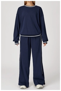 Vue détaillée de l'ensemble sweat-shirt bleu marine et pantalon large à rayures blanches