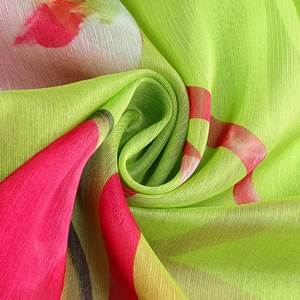 Détail macro du tissu en mousseline vert avec un imprimé floral abstrait vibrant
