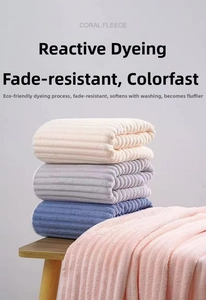 Macro shot showing the soft coral fleece fiber texture and striped weave of these towels
