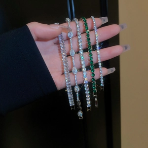 Gros plan de cinq bracelets tennis en zircon avec tailles émeraude, ovale et ronde