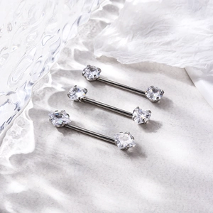 Détail des piercings de téton en acier 16G avec zircons carrés et ronds brillants