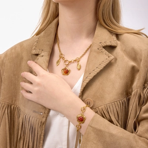 Detail of vintage gold flower necklace and bracelet set with red agate stones on a model