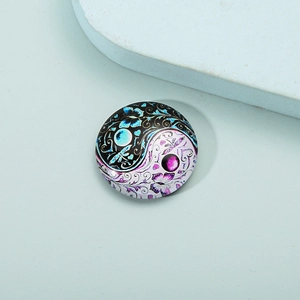 Detailed macro view of a circular glass mandala magnet with yin yang butterfly motif