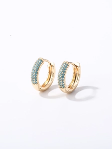 Détail de boucles d'oreilles dorées avec trois rangées de perles turquoise et fermoir