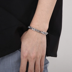 Nahaufnahme eines silbernen rechteckigen Gliederkettenarmbands aus poliertem Edelstahl für Unisex