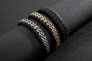 Detailed view of woven leather bracelets in silver, gold, and black steel for men