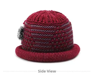 Side view of wine red winter knit hat featuring purple stripes and faux fur pom-pom