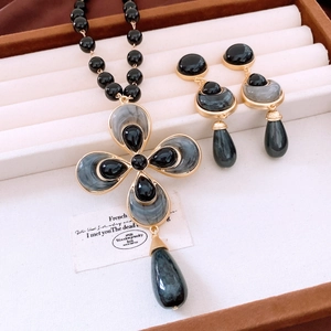 Detail view of vintage flower beaded necklace and earrings set in a luxury jewelry box