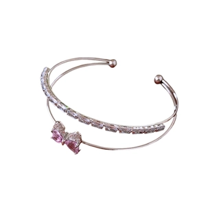 Double-layered rose gold bangle with pink crystal bow and rectangular zircon accents