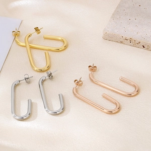 Détails de boucles d'oreilles en U en acier doré, argenté et rose sur tissu de soie