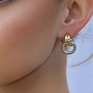 Boucles d'oreilles bicolores en acier inoxydable poli portées par un mannequin