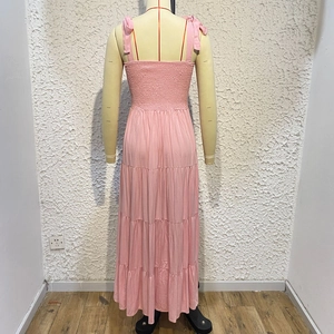 Detail of pink tiered maxi dress with adjustable tie straps and a layered ruffle skirt