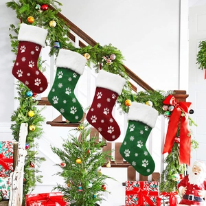 Detailed view of red and green pet Christmas stockings with paw prints and snowflake embroidery