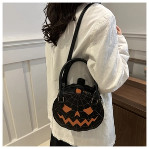 Detailed view of pumpkin-shaped crossbody bag with orange jack-o-lantern face and spider web
