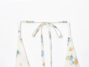 Détail des bretelles à nouer sur une robe en popeline à imprimé floral bleu et jaune