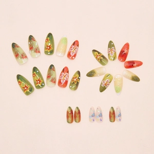 Detailed close-up of floral almond press-on nails with 3D pearls and watercolor smudge effect