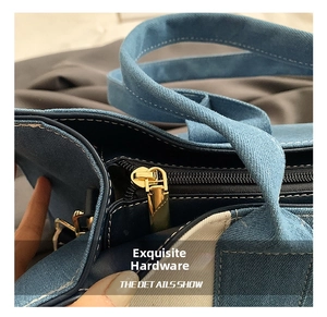 Detailed close-up of golden zipper hardware on colorblock denim tote bag with white stitching