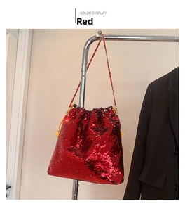 Detail of red sequin bucket bag with gold chain strap and drawstring closure