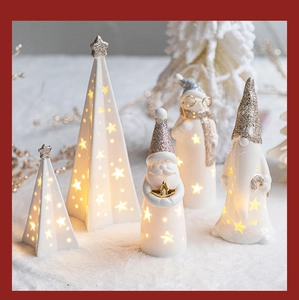 Close-up of ceramic Christmas ornaments with LED star lights and gold glitter finish
