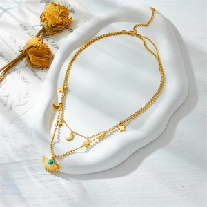 Vintage gold layered necklace with sun and moon pendants featuring turquoise inlay stone