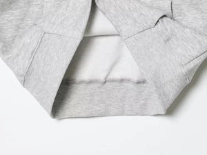 Detail von hellgrauem Fleecefutter und elastischem Rippsaum an einem Kapuzenpullover
