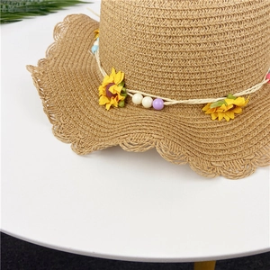 Detail of scalloped straw hat brim with sunflower fabric blossoms and colorful beads