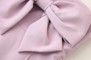 Detailed close-up of a large decorative bow on a sweet dusty pink strapless dress