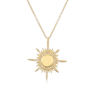 Gold plated sun pendant necklace with hollow evil eye design and zircons on white background