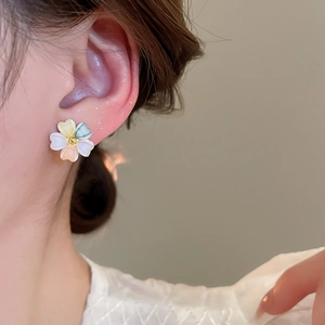 Close-up of 18k gold plated colorful acrylic flower stud earrings worn on a model ear
