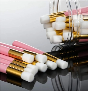 Close-up of portable nose cleaning brushes with pink handles and soft white bristles