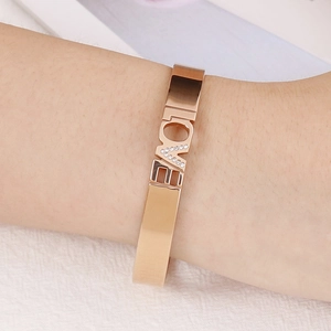 Rose gold LOVE letter open bangle with sparkling crystals shown on a wrist