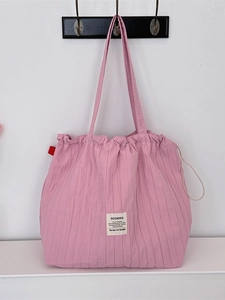 Sac cabas en tissu plissé rose avec rayures verticales, cordon de serrage et étiquette