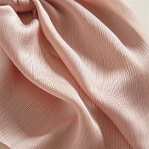 Pink scrunchie hair tie in soft pleated nylon fabric for elegant women ponytail styling